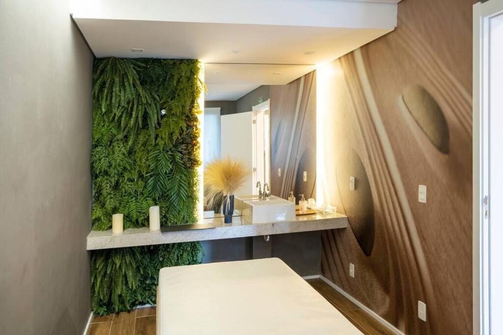 uma casa de banho com uma parede verde e um espelho. em Studio Laguna 380 em São Paulo