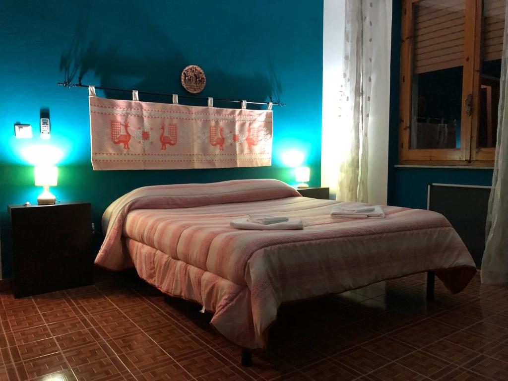 una camera da letto con un letto con pareti blu e due lampade di B&B Daddanca ad Ales