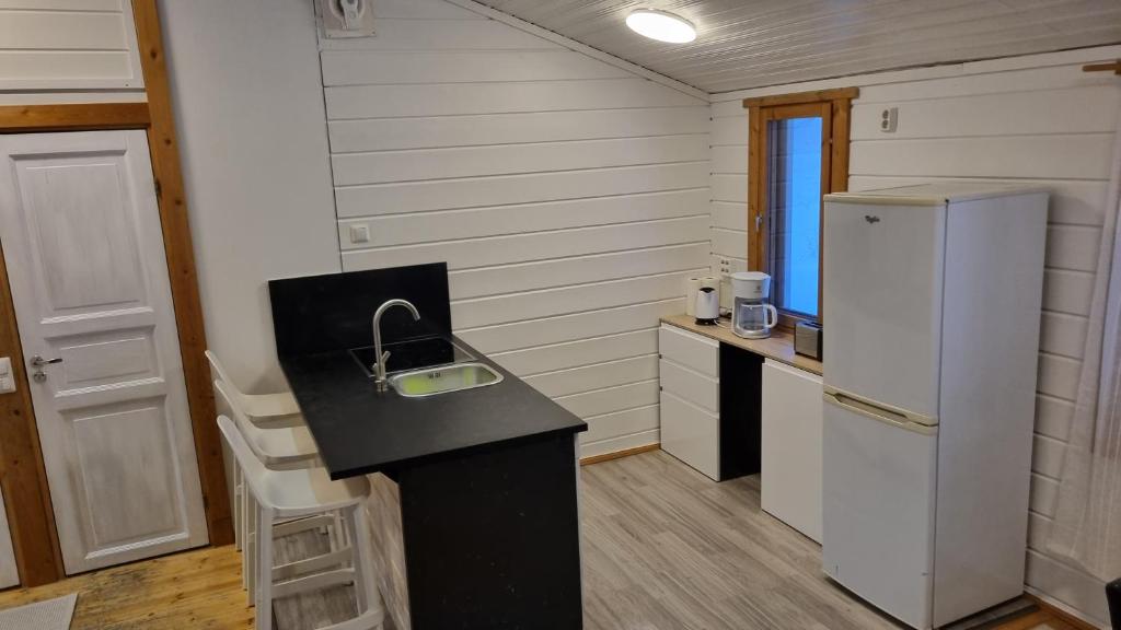 een keuken met een zwart aanrecht en een koelkast bij Lomariihi 6 in Jyväskylä