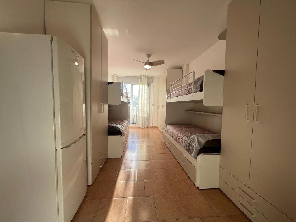 a room with two bunk beds and a refrigerator at Einaudi Sweet Home - Cologno Monzese in Cologno Monzese