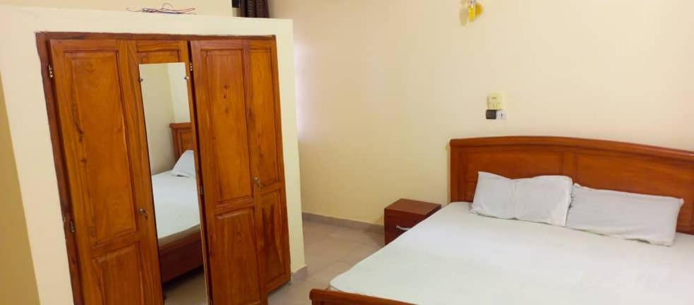 um pequeno quarto com uma cama e um closet em Appartement meublé deux chambres salons em Cotonou