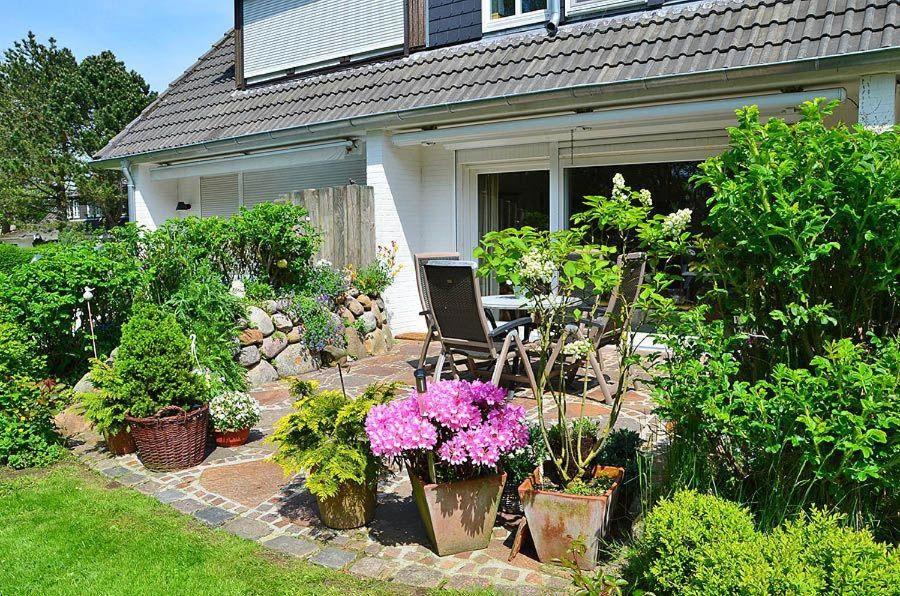 a garden with plants and flowers in front of a house at Haus-Archsum in Archsum
