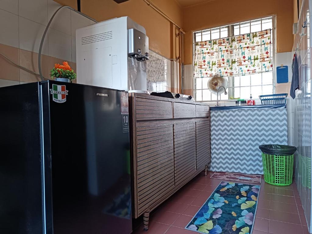 a small kitchen with a refrigerator and a window at M.FR Homestay Pangsapuri Putra Damai in Putrajaya