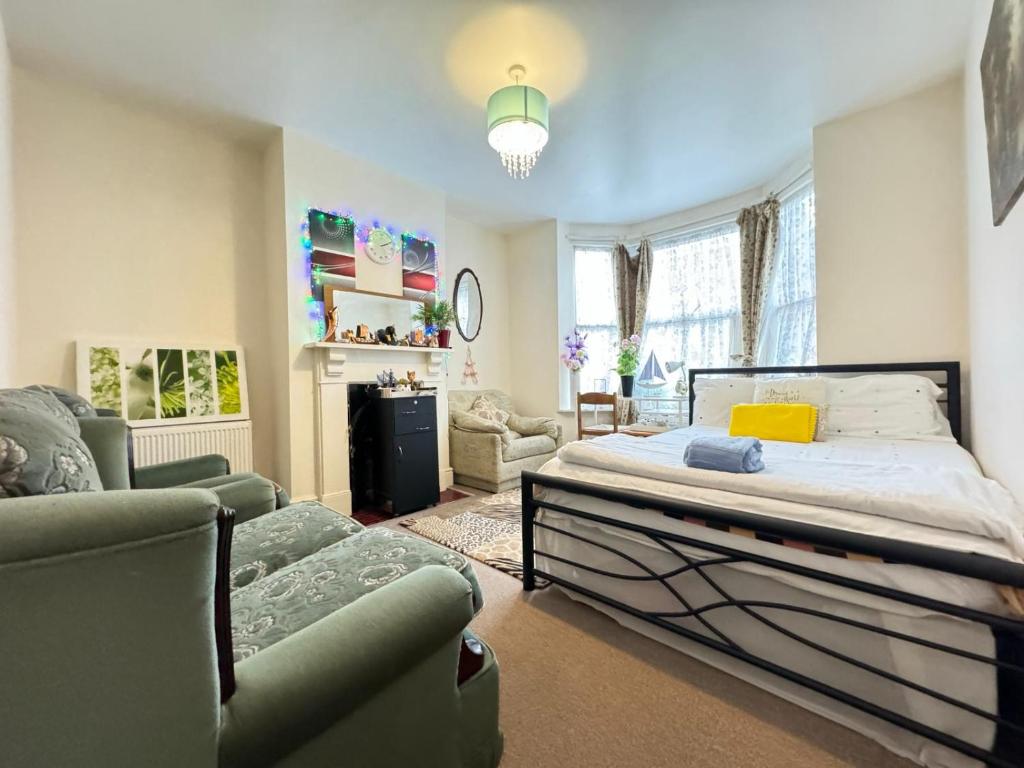 a bedroom with a bed and two chairs in it at Big Private Room In Town Centre in Eastleigh