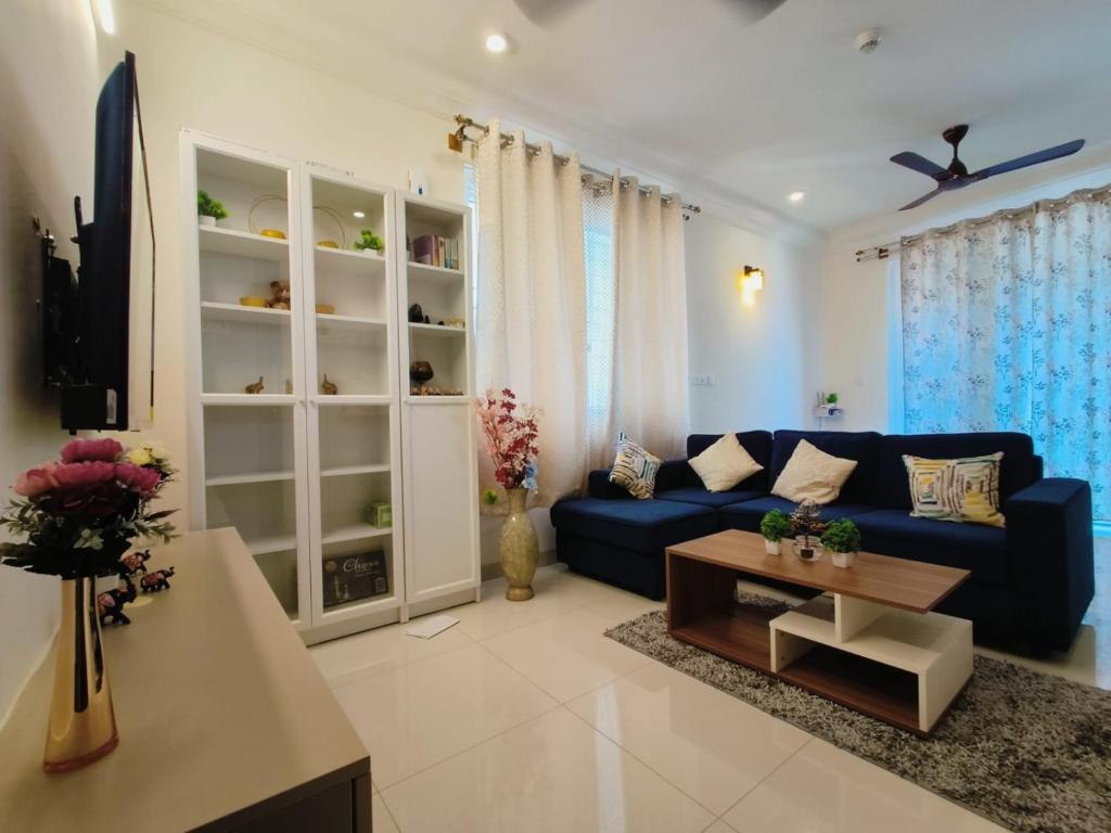 sala de estar con sofá azul y mesa en Anvaya Tranquility, en Bangalore
