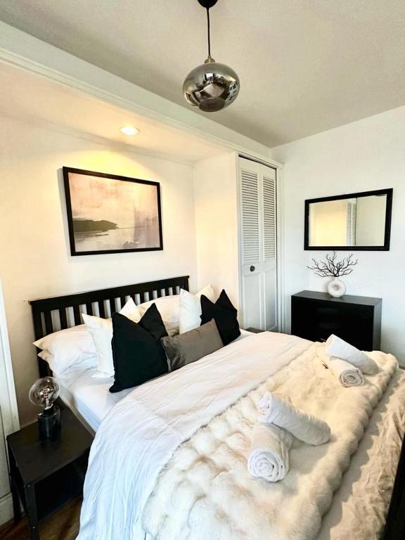 a bedroom with a large bed with white sheets and pillows at Luxury Studio Kensington London - 24 7 Security in London