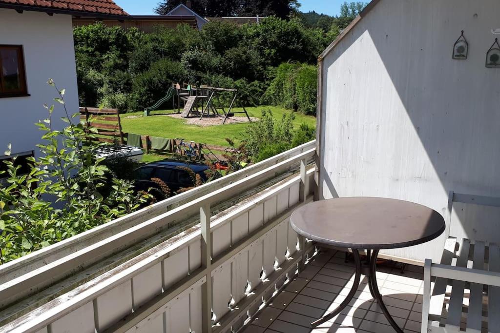 ObergünzburgにあるGemütliche Wohnung nahe Kempten (Obergünzburg)の遊び場を望むバルコニー(テーブル付)