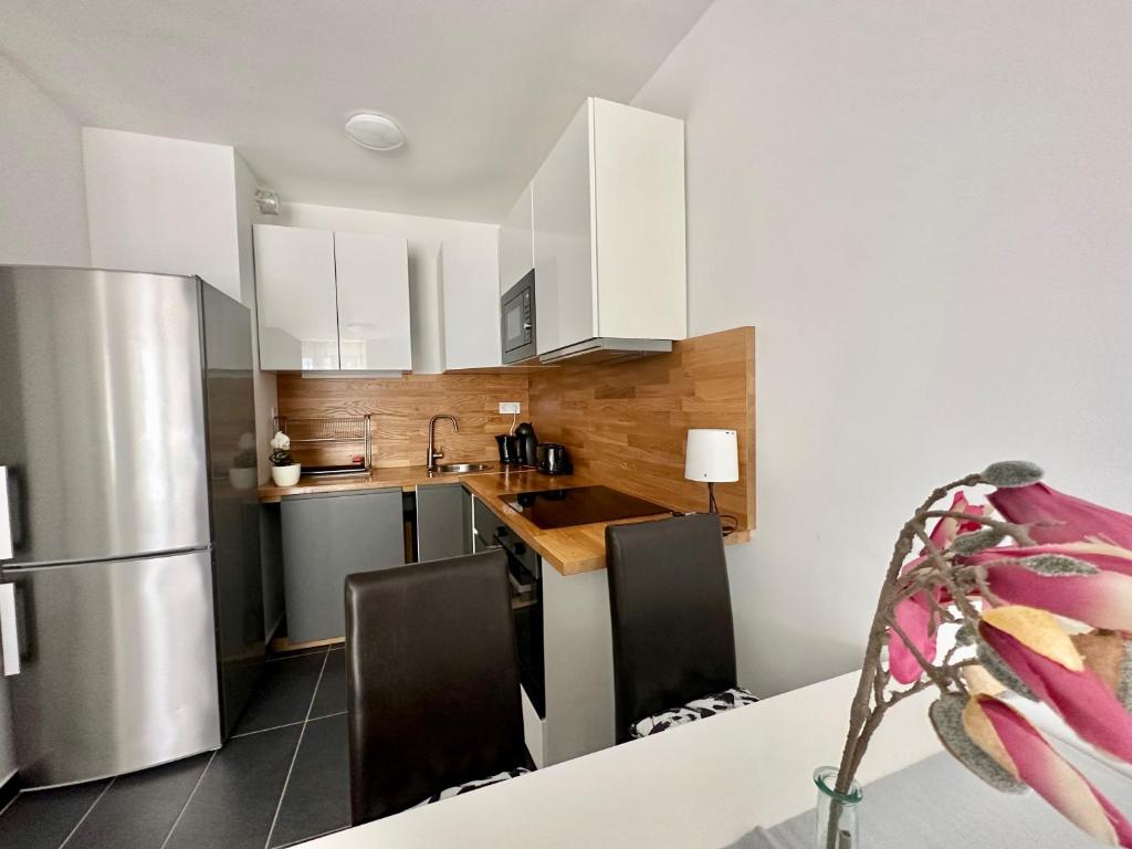 uma cozinha com armários brancos e um frigorífico de aço inoxidável em Panorama Apartment #W6 #Terrace #FreeParking em Budapeste