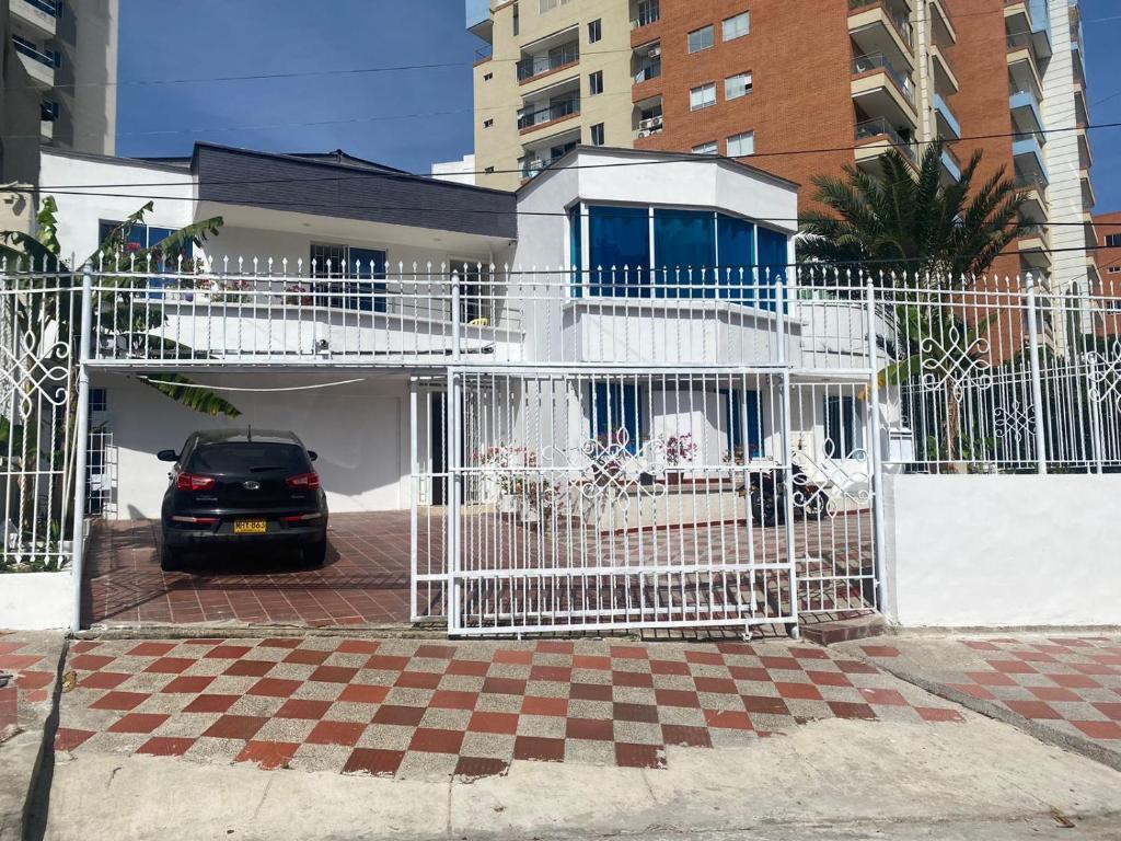 een witte poort met een auto voor een gebouw bij Casa Blanca Ciudad Jardín in Barranquilla