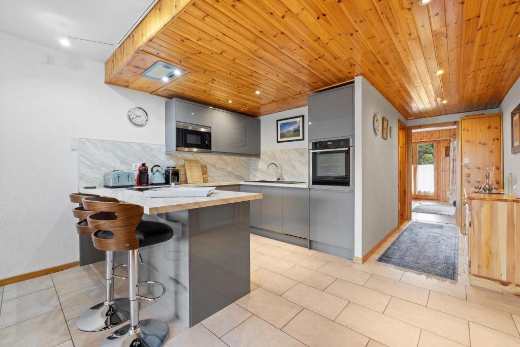 a kitchen with a counter and a wooden ceiling at Chaedoz 14-1 - 4 pers - au calme in Nendaz