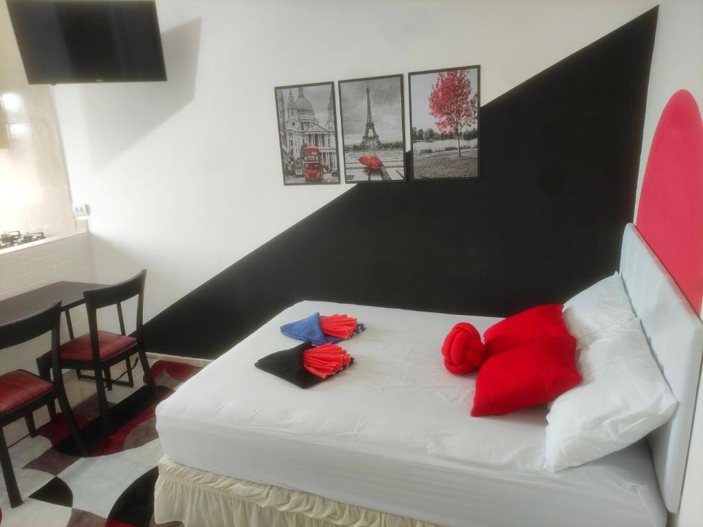 a bedroom with a white bed with red and blue pillows at Apartamento próx do centro São Bernardo do Campo in São Bernardo do Campo