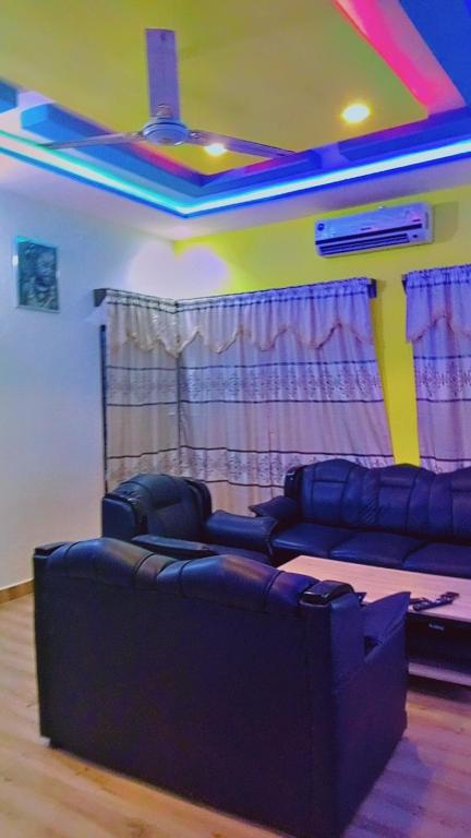 een woonkamer met 2 banken in een kamer met een plafond bij Guest house AKPAKPA in Cotonou