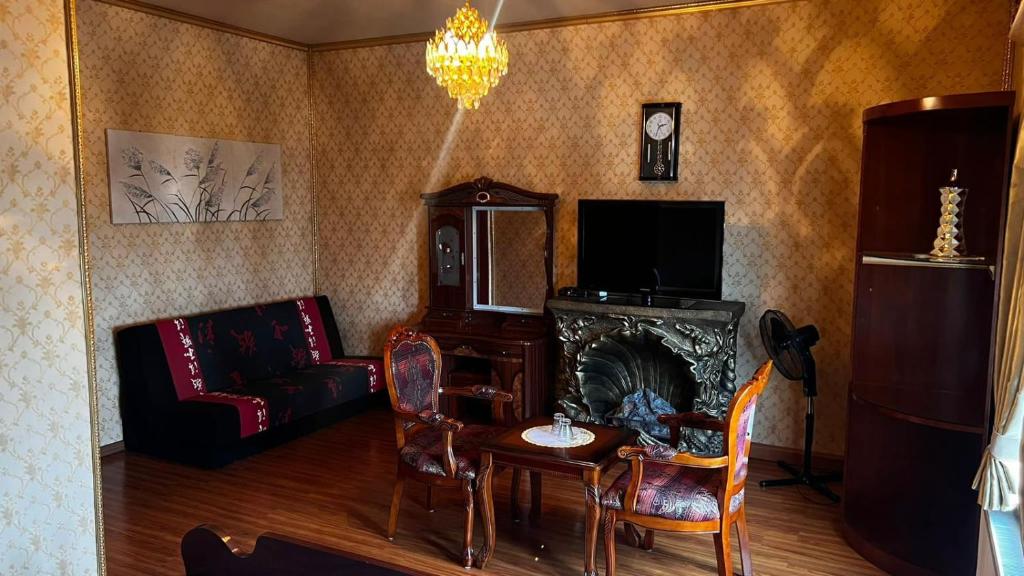 sala de estar con sofá, mesa y chimenea en Hotel & Restaurant Com Viet en Oschatz