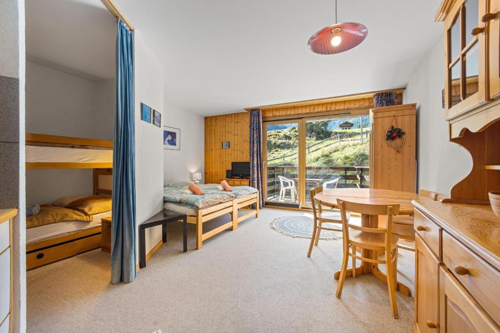 Un dormitorio con una litera y una mesa. en Mont-Fort 12 - 4 pers - au pied des pistes, en Noveli