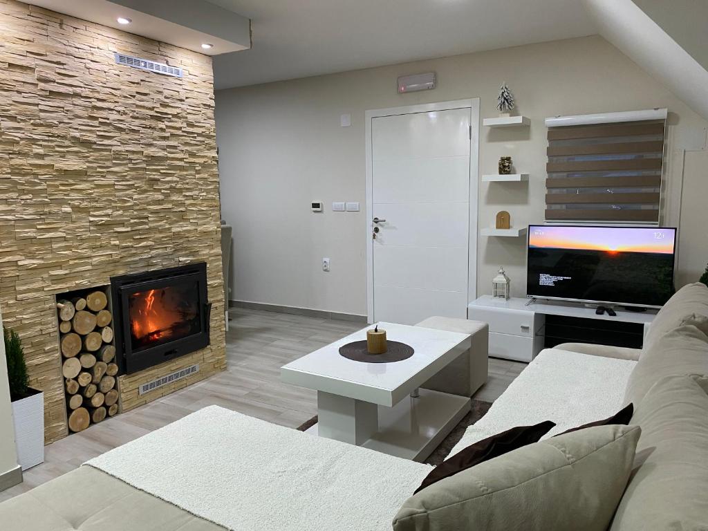 a living room with a couch and a fireplace at Ena lux Divčibare in Divčibare