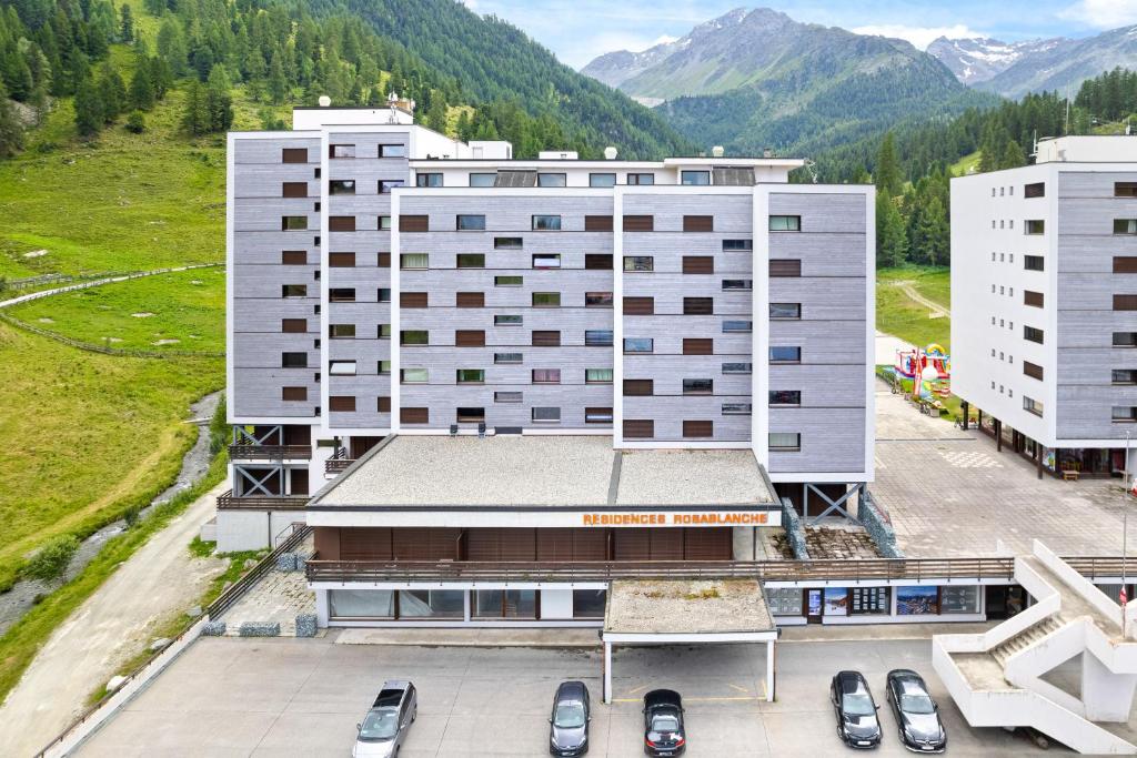 une vue aérienne d'un bâtiment avec des voitures garées sur un parking dans l'établissement Rosablanche B12-B13 - 4 pers - au pied des pistes, à Siviez