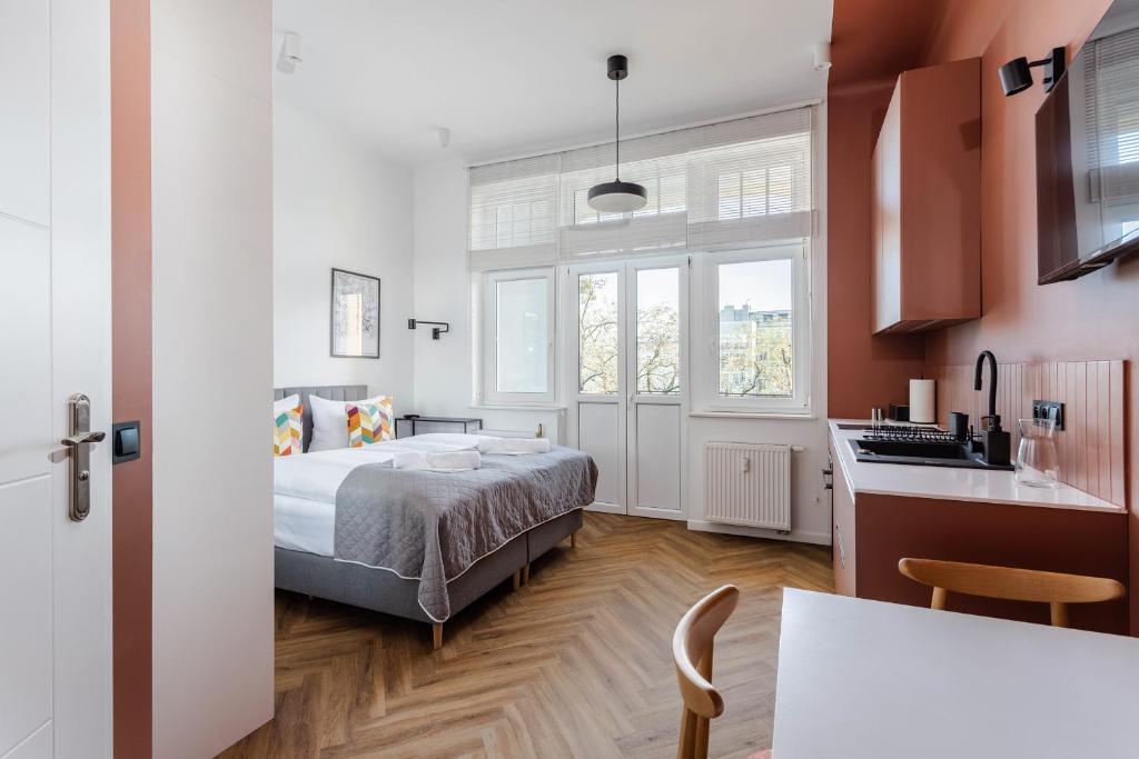 um pequeno quarto com uma cama e uma cozinha em Very Berry - Kochanowskiego 6/4 - Jeżyce, self check in 24h em Poznań