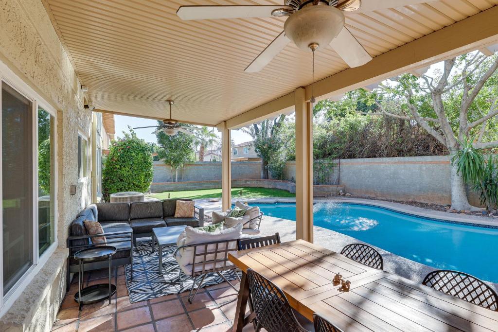 a patio with a table and chairs next to a pool at Stunning Tempe Home with Pool - Near ASU Campus! in Tempe