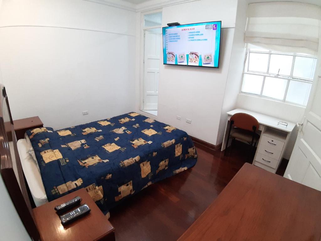 Habitación pequeña con cama y escritorio. en APARTAMENTO LINDO - A 2 Cuadras de la Plaza de Armas y del Palacio de Gobierno, en Lima