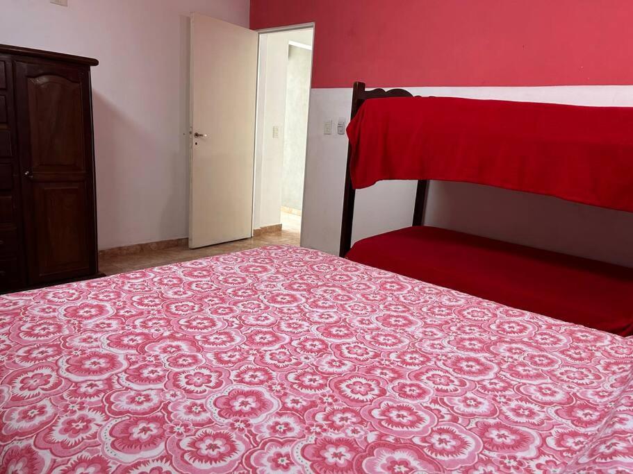 a bedroom with a bed and a red wall at Departamento 2 ambientes in Bella Vista