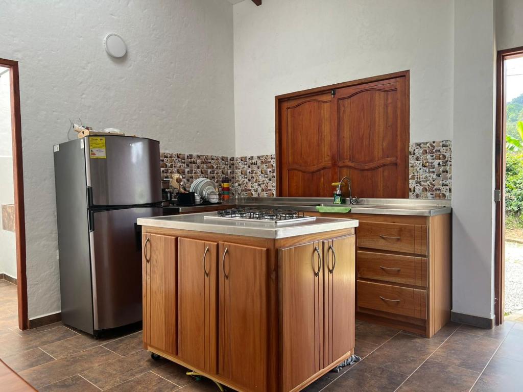een keuken met houten kasten en een roestvrijstalen koelkast bij Campo Bonito in Jericó