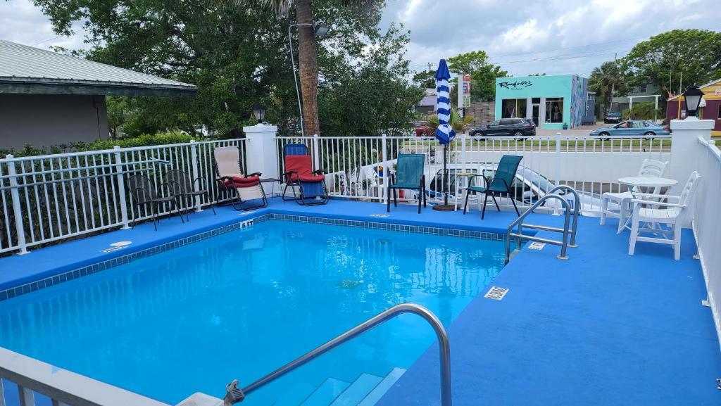 a blue swimming pool with chairs and a table at Historic Inn - Saint Augustine in St. Augustine