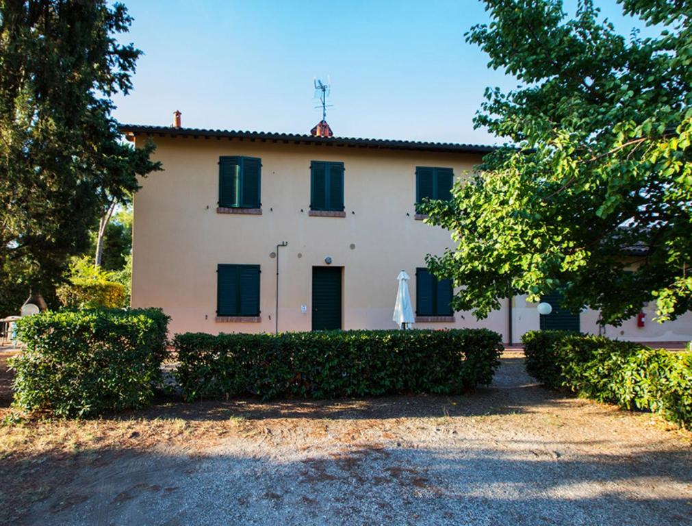 een groot wit huis met groene luiken bij Podere Simonetta - A11 in Cecina