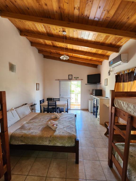 a bedroom with a large bed and a kitchen at Los Abuelos Apart in General Pico