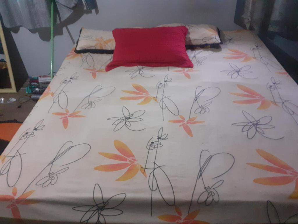 Una cama con un edredón blanco con flores. en Vila kauwamura en Belém