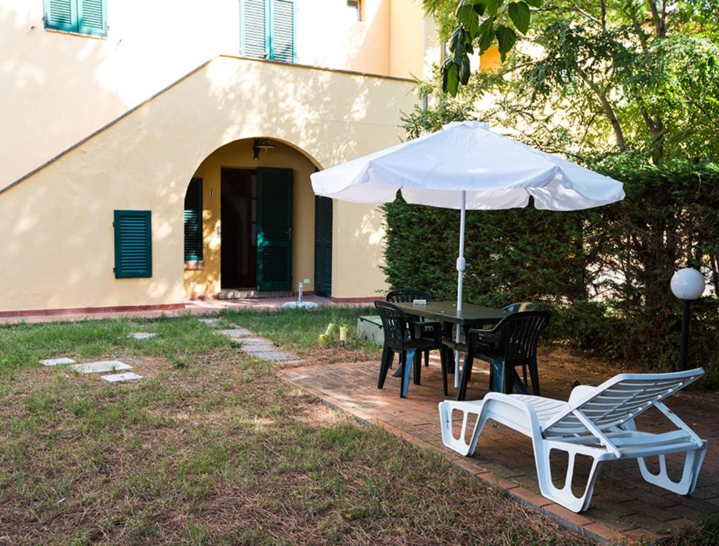 een tafel en stoelen en een parasol in de tuin bij Podere La Pinetina - Ct1 in Cecina
