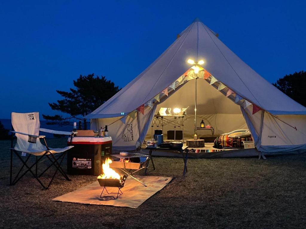 a tent with a fire in front of it at night at Tanesashi Campsite - Camp - Vacation STAY 46937v in Hachinohe