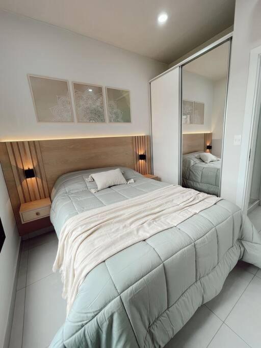a bedroom with a large bed and a mirror at Acogedor departamento! in Luque