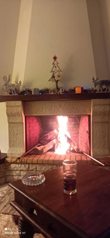 ognisko w kominku ze stołem i szkłem w obiekcie Όμορφο Κατάλυμα στην Άνω Πόλη Πάτρας w mieście Patras