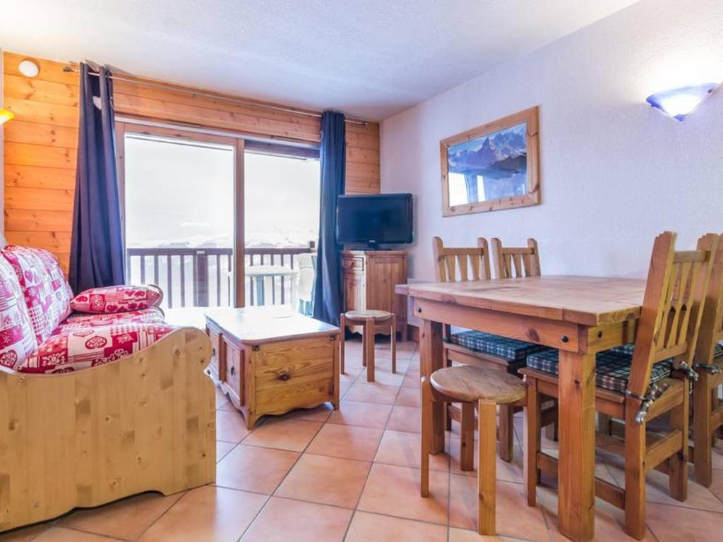 a living room with a dining room table and a couch at Appartement Les Arcs 1800, 3 pièces, 6 personnes - FR-1-346-320 in Arc 1800