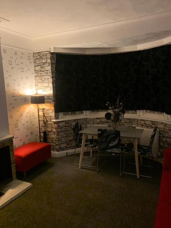 Spacious 1 bedroom en-suite, kitchen and garden space في إلفورد: غرفة بطاولة ولوحة على الحائط