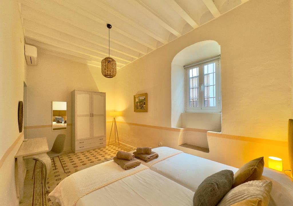 a bedroom with a large white bed in a room at DS Palacio de la Luna in Córdoba