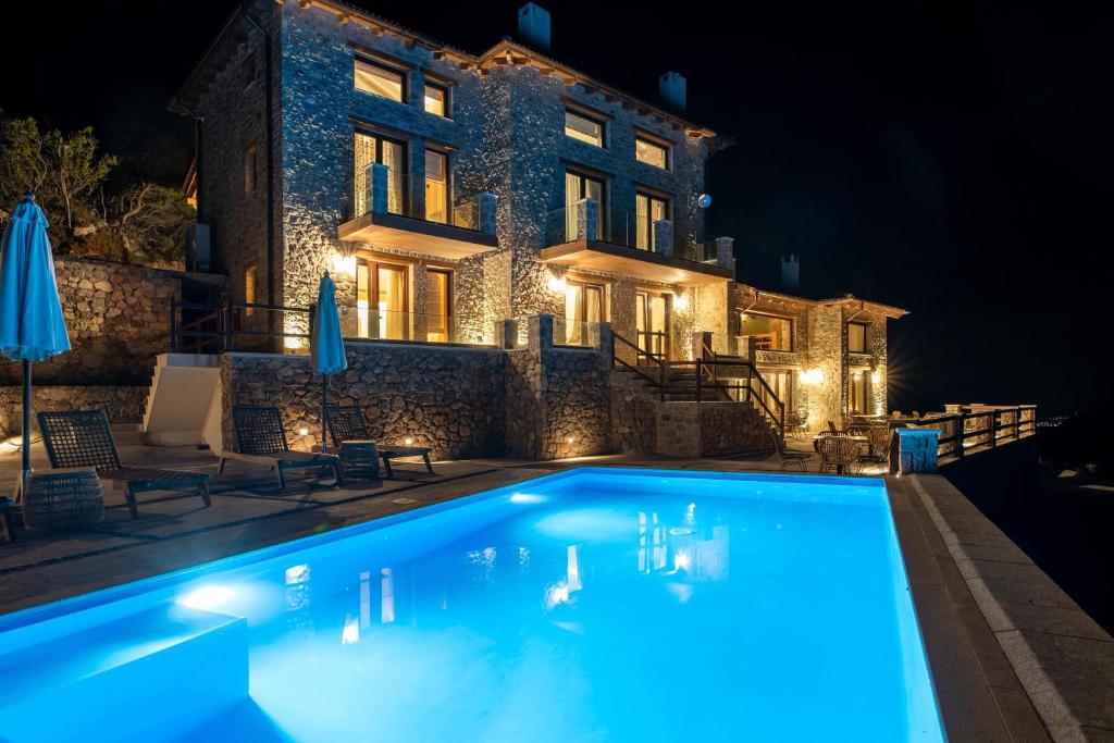 uma villa com piscina à noite em 5 Raches Suites em Arachova