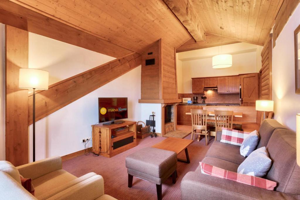 a living room with a couch and a kitchen at Résidence Les Arcs Le Village - maeva Home - Appartement pièces - Sélecti 691 in Arc 1950