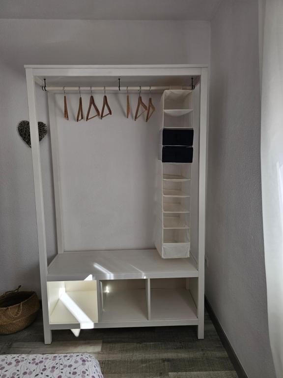 a white closet with white shelves and hangers at Apartamentos La Mar in Altea