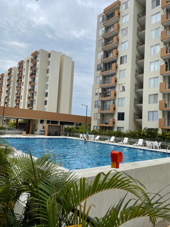 a swimming pool in front of two tall buildings at Apartamento Girardot Peñalisa con Piscina in Ricaurte