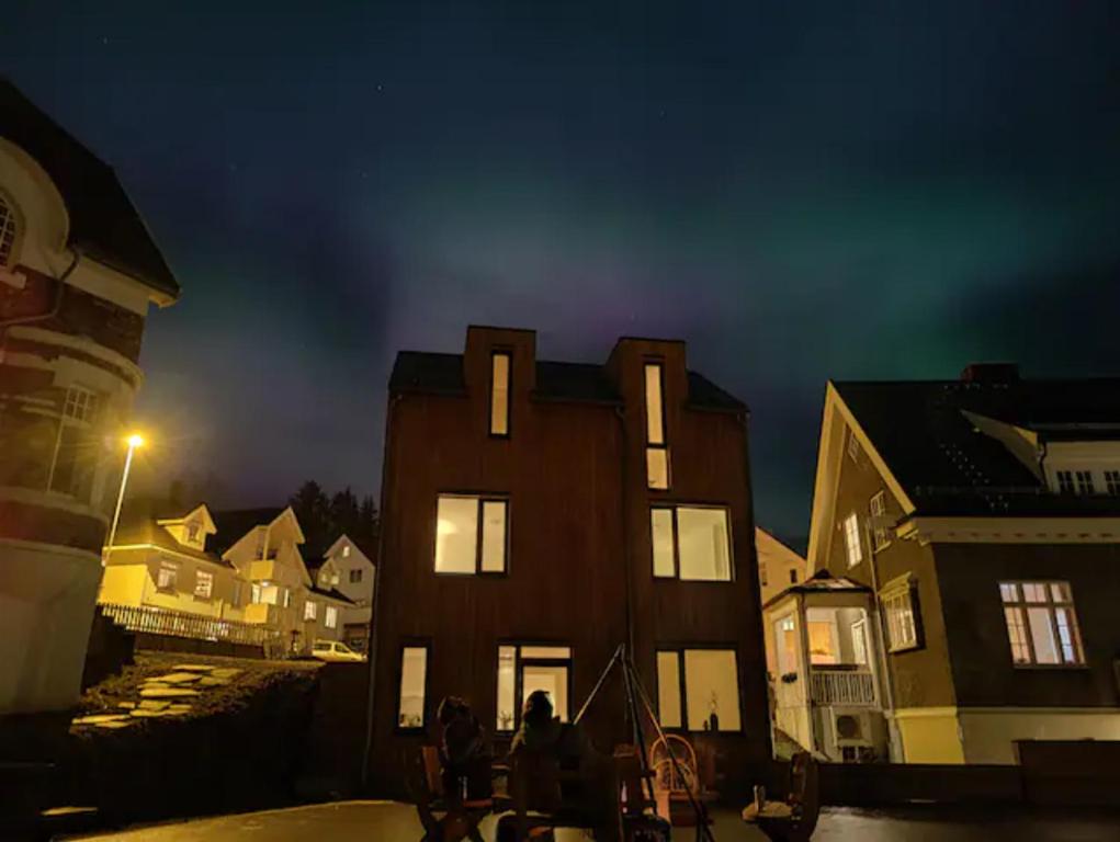 een groep mensen die 's nachts voor een gebouw staan bij Modern Villas in Plush town in Tromsø