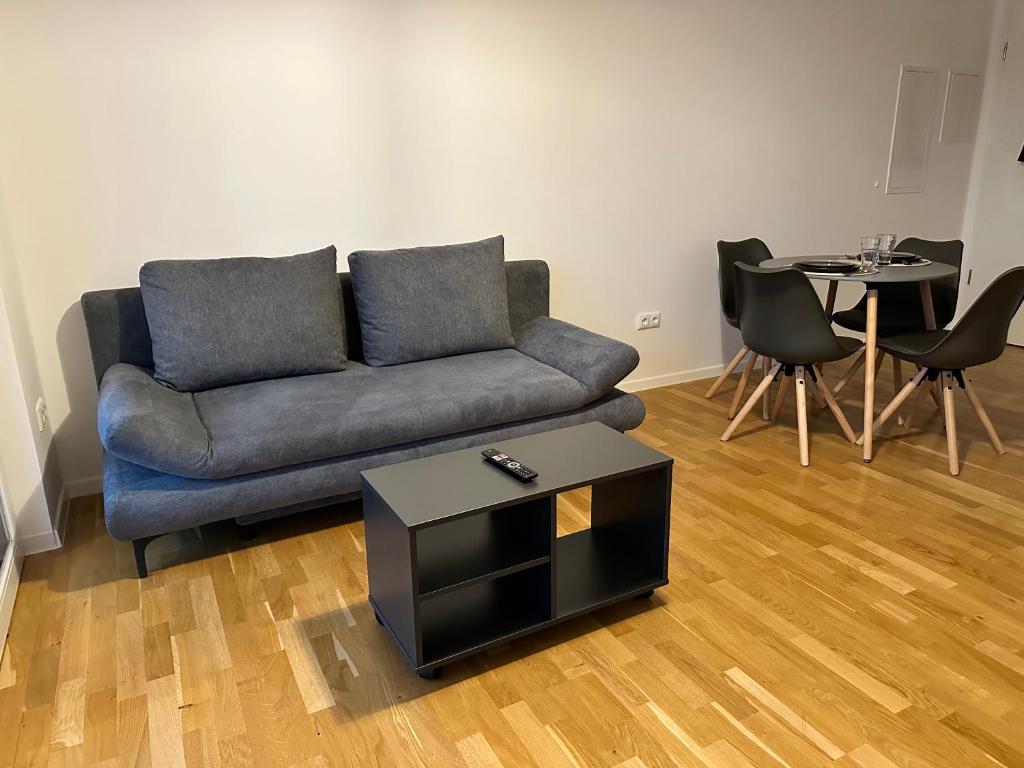 uma sala de estar com um sofá e uma mesa em Gemütliche Wohnung mit Terrasse em Blumberg