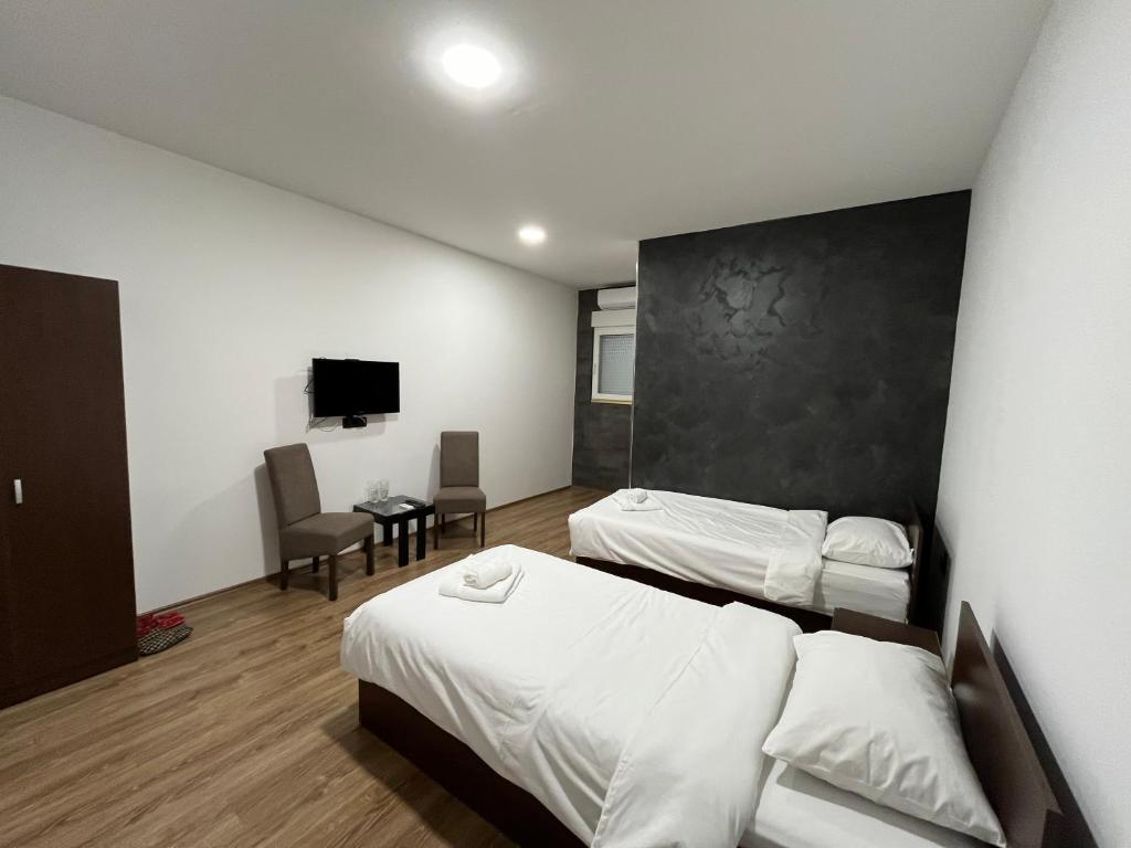 Habitación de hotel con 2 camas y TV en Apartmani Bosfor, en Niška Banja