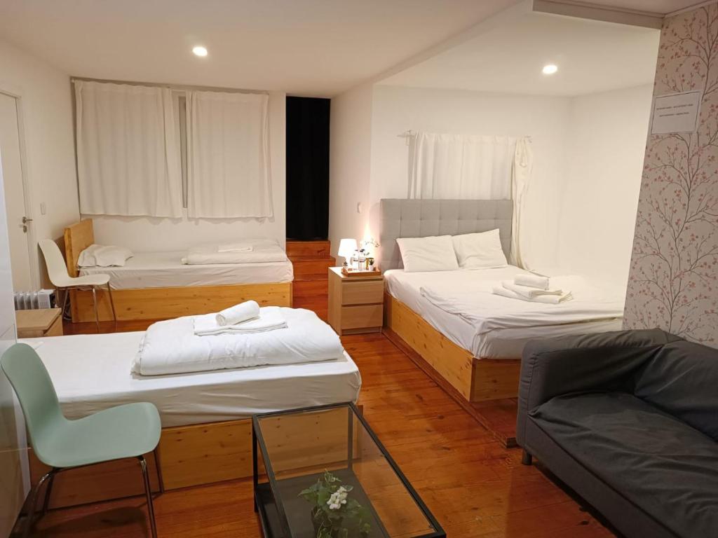 a small room with two beds and a couch at Sylhet BNB in Lisbon