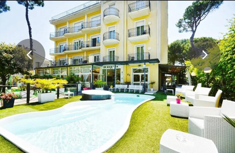 um hotel com uma grande piscina no quintal em Hotel Europa Milano Marittima em Milano Marittima
