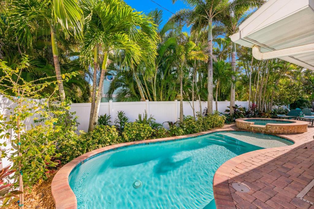 einen Pool im Hinterhof mit Palmen in der Unterkunft Blue Coral Beach House in Holmes Beach
