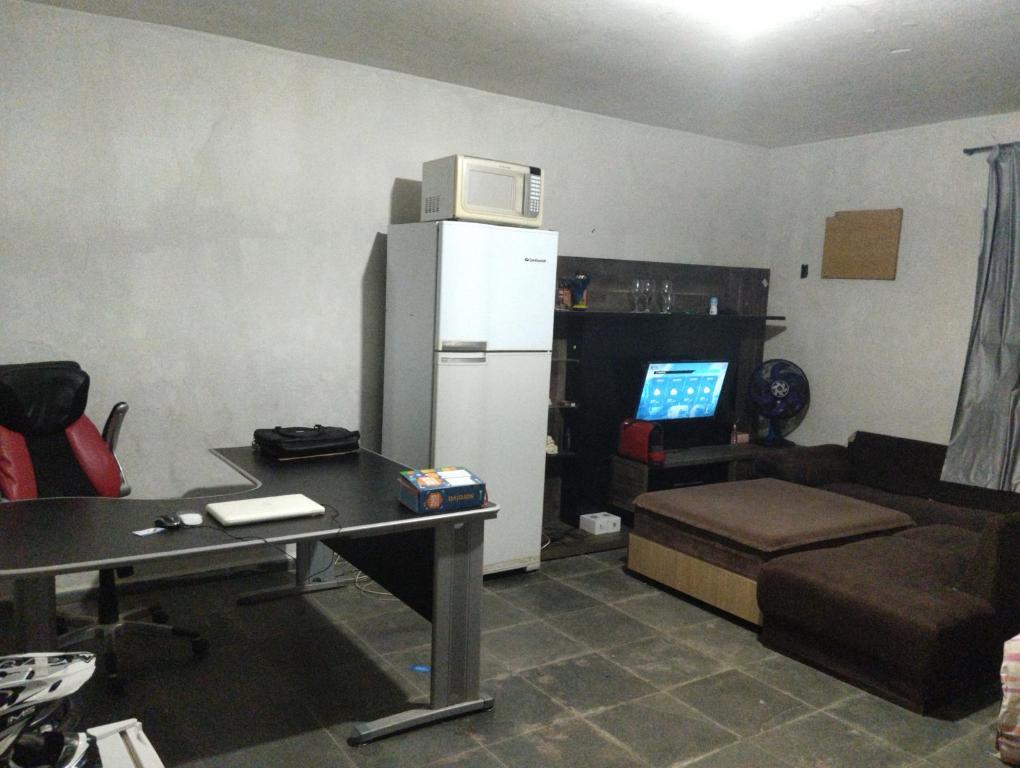 uma sala de estar com um frigorífico e um sofá em Hostel família Campineira em Campinas