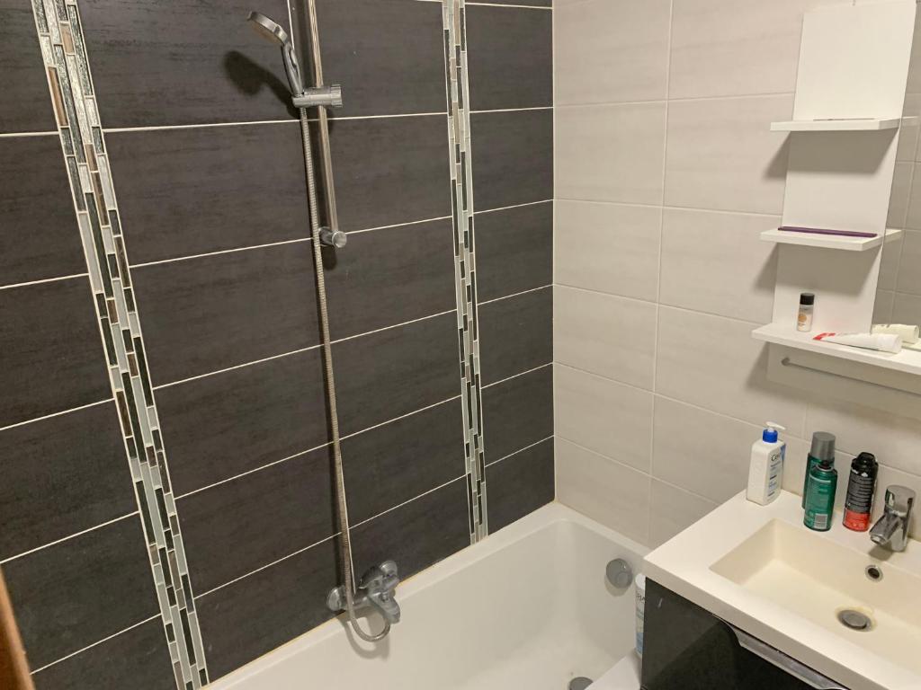 La salle de bains est pourvue d'une douche et d'un lavabo. dans l'établissement Chambre dans appartement, à Bagneux