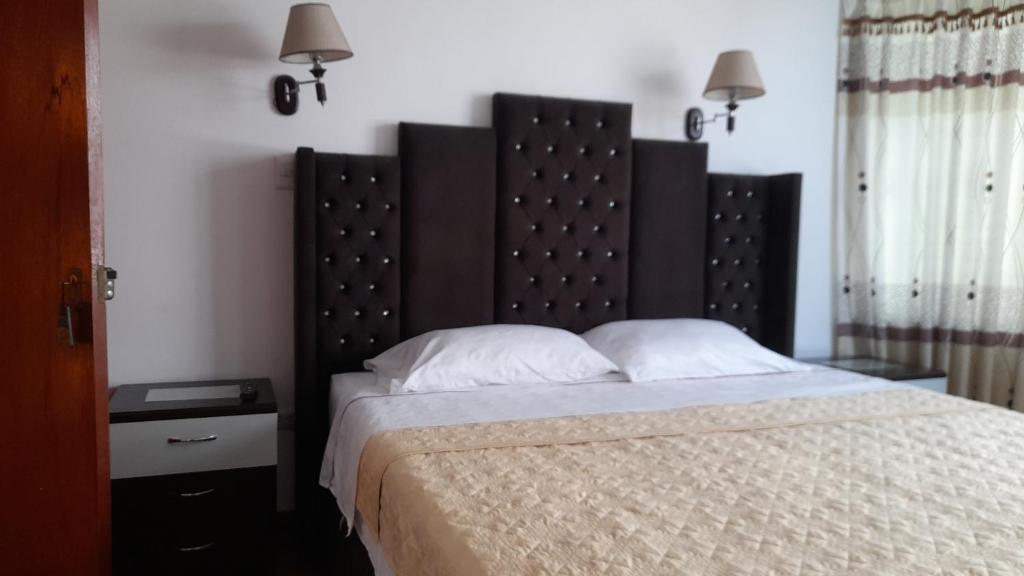 a bed with a large headboard in a bedroom at Hostal Mansion Dorada in Tacna