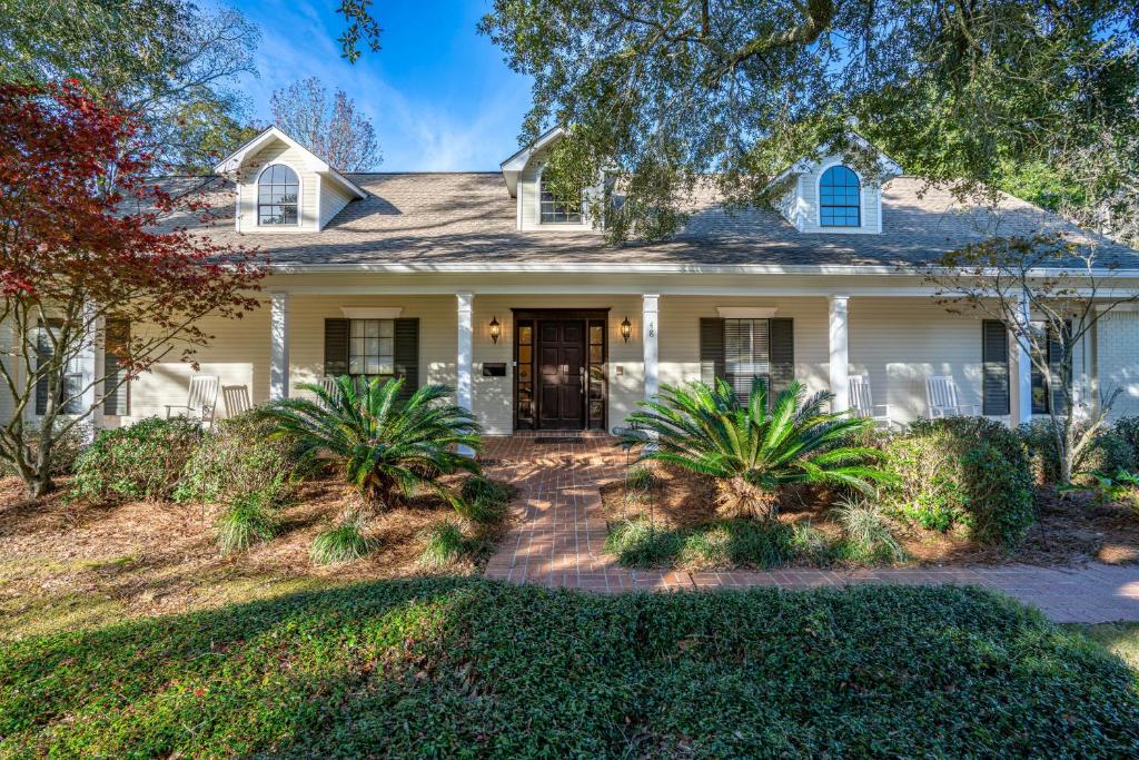 a white house with palm trees in front of it at Yellow Adirondack Hideaway in Gulfport